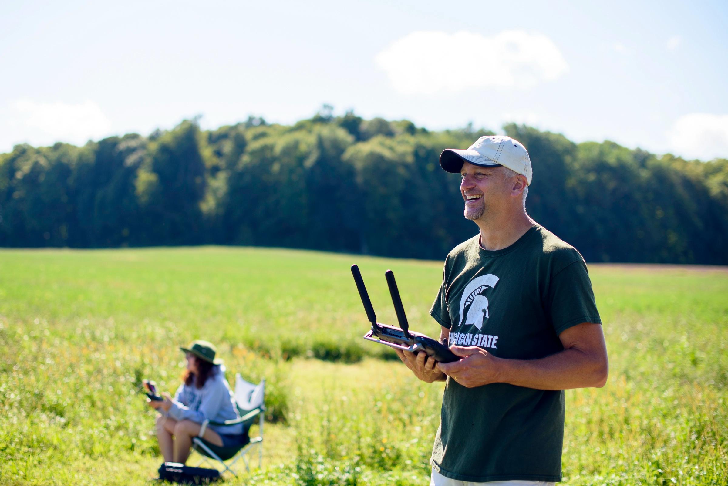 An analyst smiling and holding a drone controller