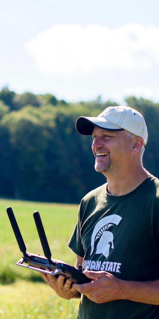 An analyst smiling and holding a drone controller