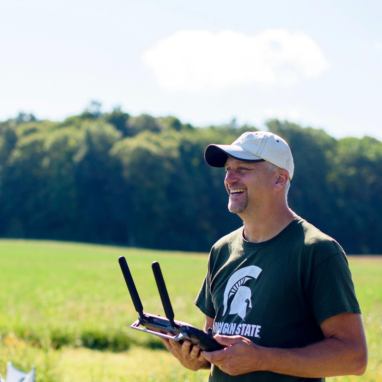 An analyst smiling and holding a drone controller